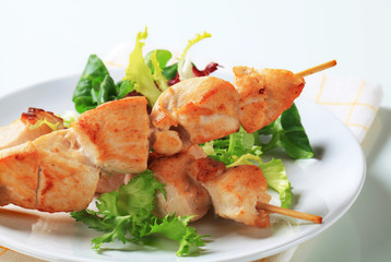 Chicken skewers and salad greens