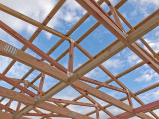 Roof frame construction under cloudy blue sky