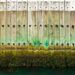 Old wooden pier wall with tidal waterline