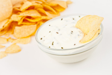 Bowl of  dip with herbs beside chips
