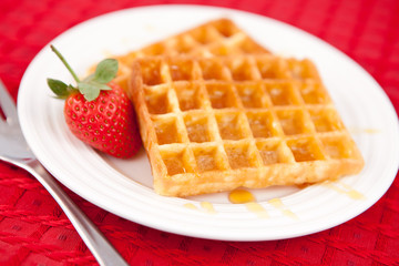 Waffles and strawberry together in a white plate