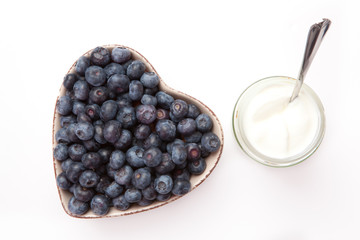 White yogurt and blueberries in a heart shaped bowl