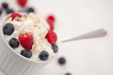 Jar of fruits and whipped cream with spoon