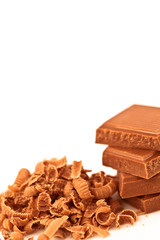 Four pieces of chocolate piled beside chocolate shavings