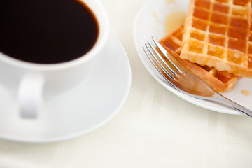 Obraz na płótnie Canvas Waffles placed next to a coffee cup
