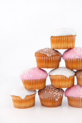 Many muffins with icing sugar placed in pyramid