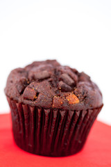 Dark chocolate muffin on a red table