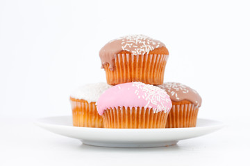 Muffins with icing sugar piles up on a white plate