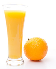 Orange next to a glass of orange juice
