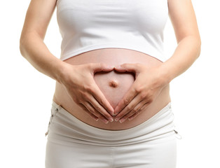Pregnant woman holding her hands in a heart shape on her pregnan - 41377350