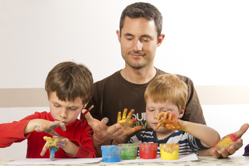 Vater malt mit seinen Kindern mit Fingerfarbe