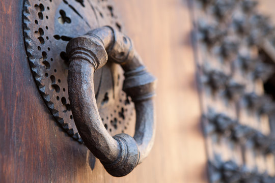 Aldaba de hierro forjado en puerta de madera antigua