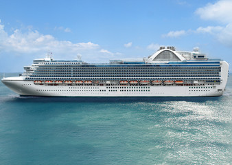 Luxury cruise ship sails away at sunny day