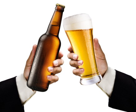 Two men's hands with a glass and a bottle of beer