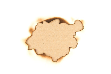 Burnt hole in a paper over brown paper background