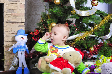 small boy with gift near fir trees