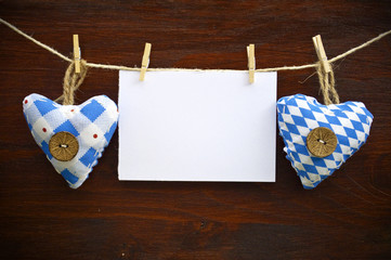 2 Stoffherzen mit Blankokarte auf Holzbrett