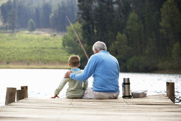 Senior man vissen met kleinzoon