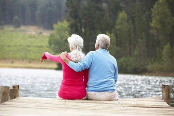 Senior couple sitting on a jetty