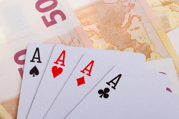 Four aces on top of some 50 euro banknotes