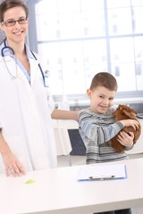 Fototapeta premium Smiling kid with pet rabbit at veterinary