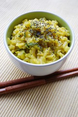 Yellow rice with saffron and zucchini in a bowl with chopsticks