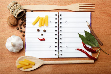 Fototapeta premium notebook for recipes and spices on wooden table