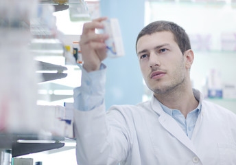 pharmacist chemist man in pharmacy drugstore