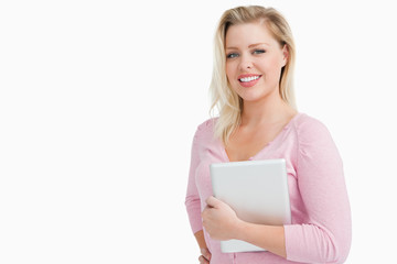 Joyful blonde woman holding her tablet computer