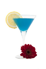 cocktailglas mit zitronenscheibe und gerberablüte