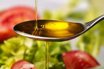 Olive oil flows into a spoon