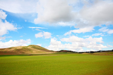Beautiful Spring landscape with hills and white clouds