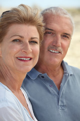 Middle-aged couple stood on beach