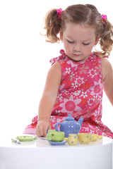 Little girl playing with model teapot and mugs - obrazy, fototapety, plakaty