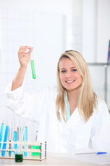 female biologist in laboratory holding test tube