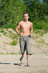 Young man running on beach