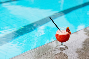 glass with drink costs on a pool side