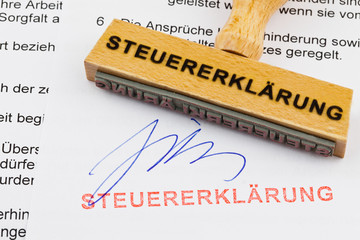 Holzstempel auf Dokument: Steuererklärung