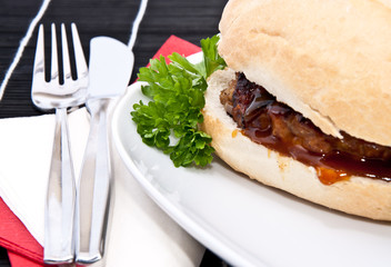 Burger on a roll with cutlery