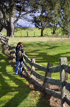 Female Photographer At Old Post And Rail Fence