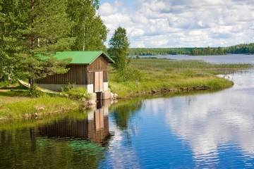 Fototapeta na wymiar Stodoła i łód¼ na jeziorze. Finlandia