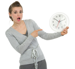 Shocked business woman pointing on clock