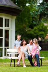 Family sitting in front of their home