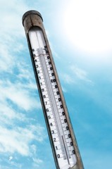 Old thermometer against blue sky