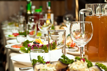 Glasses and plates on table in restaurant - food background