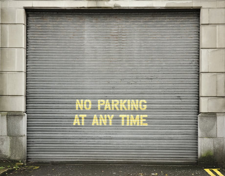 Garage door with text "no parking at any time"