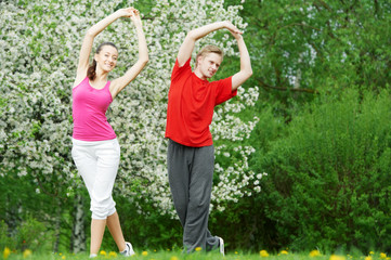 Young man and woman doing stretching exercises