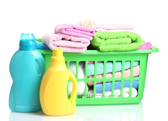 Detergents and towels in green plastic basket isolated on white