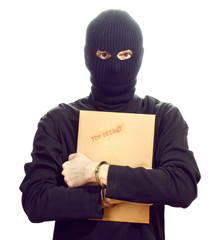 Bandit in black mask in handcuffs with top secret envelope