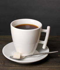 Coffee cup on wooden table on grey background